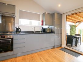 A kitchen with a sink and sliding door at Birch in Oakthorpe near Donisthorpe