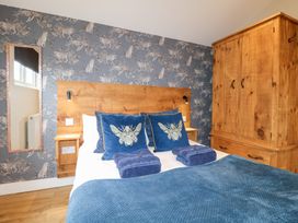 A bedroom with a bed and wooden furniture at Birch in Oakthorpe near Donisthorpe