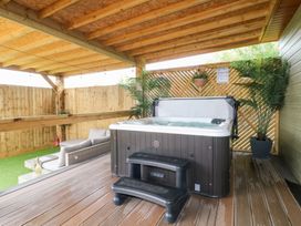 An outdoor area with a hot tub and seating at Birch in Oakthorpe near Donisthorpe