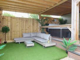An outdoor seating area with a sofa and hot tub at Birch in Oakthorpe near Donisthorpe