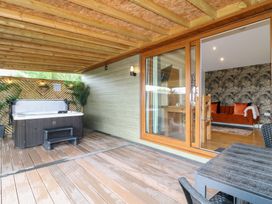 An outdoor seating area with a hot tub and table at Birch in Oakthorpe near Donisthorpe