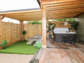 An outdoor living area with a hot tub and seating at Birch in Oakthorpe near Donisthorpe