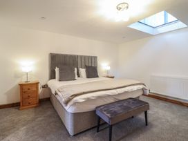 A bedroom with a double bed bedside tables lamps and a bench at Gaerau Bach in Llanaber