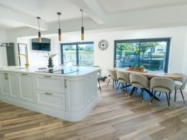 A kitchen with an island and dining area at Iscoed in Rhosneigr