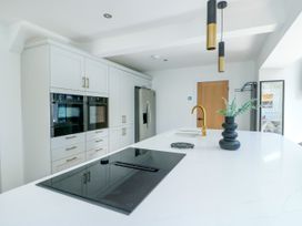 A kitchen with cabinets and appliances at Iscoed Rhosneigr