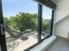 A balcony with chairs and a table at Iscoed Rhosneigr