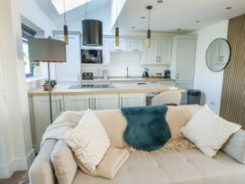 A living room with a kitchen countertop and sofa at Iscoed Rhosneigr