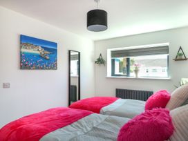 A bedroom with two beds and a window at Iscoed Rhosneigr