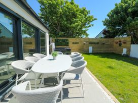 An outdoor dining area with a table and chairs at Iscoed Rhosneigr