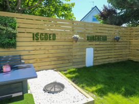 A garden with a fenced area and a table at Iscoed in Rhosneigr