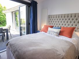A bedroom with a bed and access to outdoor seating at Yonder Lea Bowness-On-Windermere