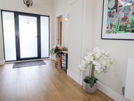 A hallway with a front door and flower arrangement at Yonder Lea in Bowness-On-Windermere