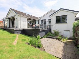 An outdoor area with a deck and garden at Yonder Lea in Bowness-On-Windermere