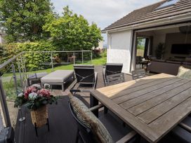 An outdoor patio with seating and a dining table at Yonder Lea in Bowness-On-Windermere