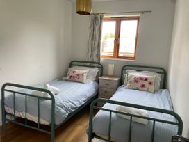 A bedroom with two beds and a bedside table at Mulberry Cottage Staple near Dartington