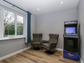 A game room with chairs and an arcade machine at Ranbir House in Longhope
