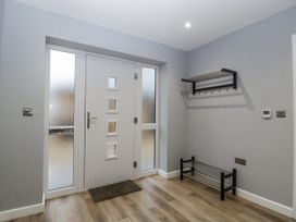 An entrance hall with a door and coat rack at Ranbir House Longhope