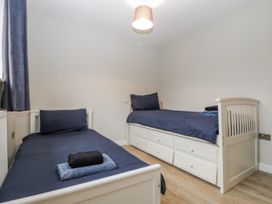 A bedroom with two beds and a nightstand at Ranbir House in Longhope