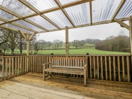 An outdoor area with a wooden bench and a roof structure at Ranbir House in Longhope