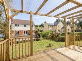 An outdoor area with decking and a view of houses and greenery at Ranbir House Longhope