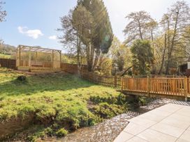 A garden with a wooden gazebo and a stream at Ranbir House Longhope