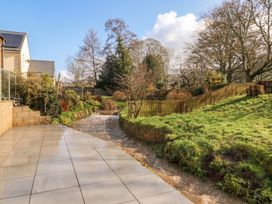 A garden with a patio and a river at Ranbir House, Longhope