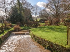 A garden with a stream and a wooden bridge at Ranbir House, Longhope