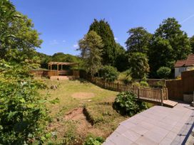 A garden with a deck and fenced area at Ranbir House in Longhope