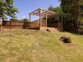 A garden with a wooden deck area at Ranbir House in Longhope