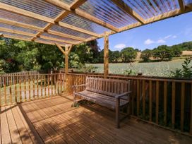 An outdoor patio with a wooden bench at Ranbir House in Longhope