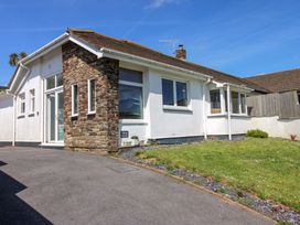 A house with a stone wall and grass area at Tansea in Hope Cove
