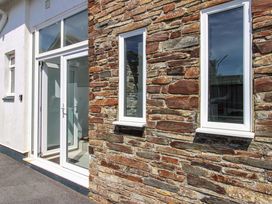 A stone wall with windows and a door at Tansea in Hope Cove