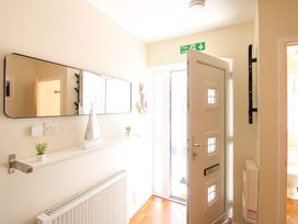 A hallway with a door and mirror at Tansea in Hope Cove