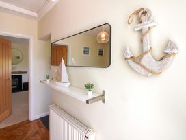 A hallway with a mirror and decor at Tansea in Hope Cove
