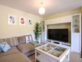 A living room with a sofa and television at Tansea in Hope Cove