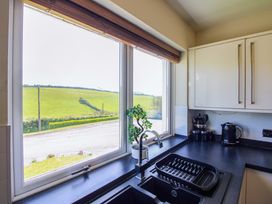 A kitchen with sink and window view at Tansea in Hope Cove