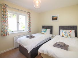 A bedroom with two beds and a window at Tansea in Hope Cove