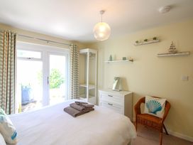 A bedroom with a bed and wardrobe at Tansea in Hope Cove