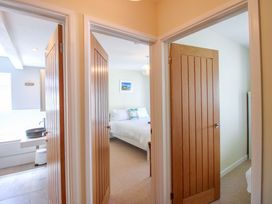 A hallway with doors leading to a bedroom and a bathroom at Tansea in Hope Cove