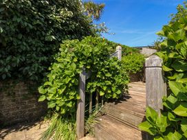 A garden pathway with wooden stairs and lush greenery at Tansea in Hope Cove