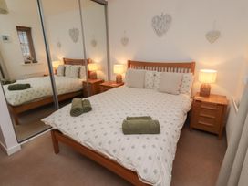 A bedroom with a double bed and bedside tables at Brucap Cottage Beadnell