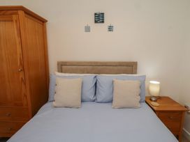 A bedroom with a bed and wardrobe at Brucap Cottage Beadnell