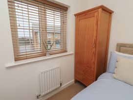 A bedroom with a window and a wardrobe at Brucap Cottage Beadnell