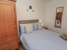 A bedroom with a bed and wardrobe at Brucap Cottage Beadnell