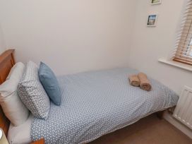 A bedroom with a bed and towels at Brucap Cottage Beadnell