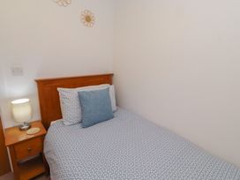 A bedroom with a bed and lamp at Brucap Cottage Beadnell