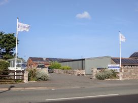 An entrance with stone walls and flags on poles at B15 Ty Gwyn in Towyn