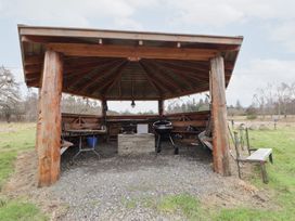 An outdoor shelter with a grill and seating area at Pod 1