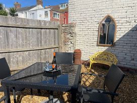 A garden with a table and chairs at Winkle Cottage in Weymouth