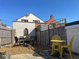 A garden with a table and chairs at Winkle Cottage in Weymouth